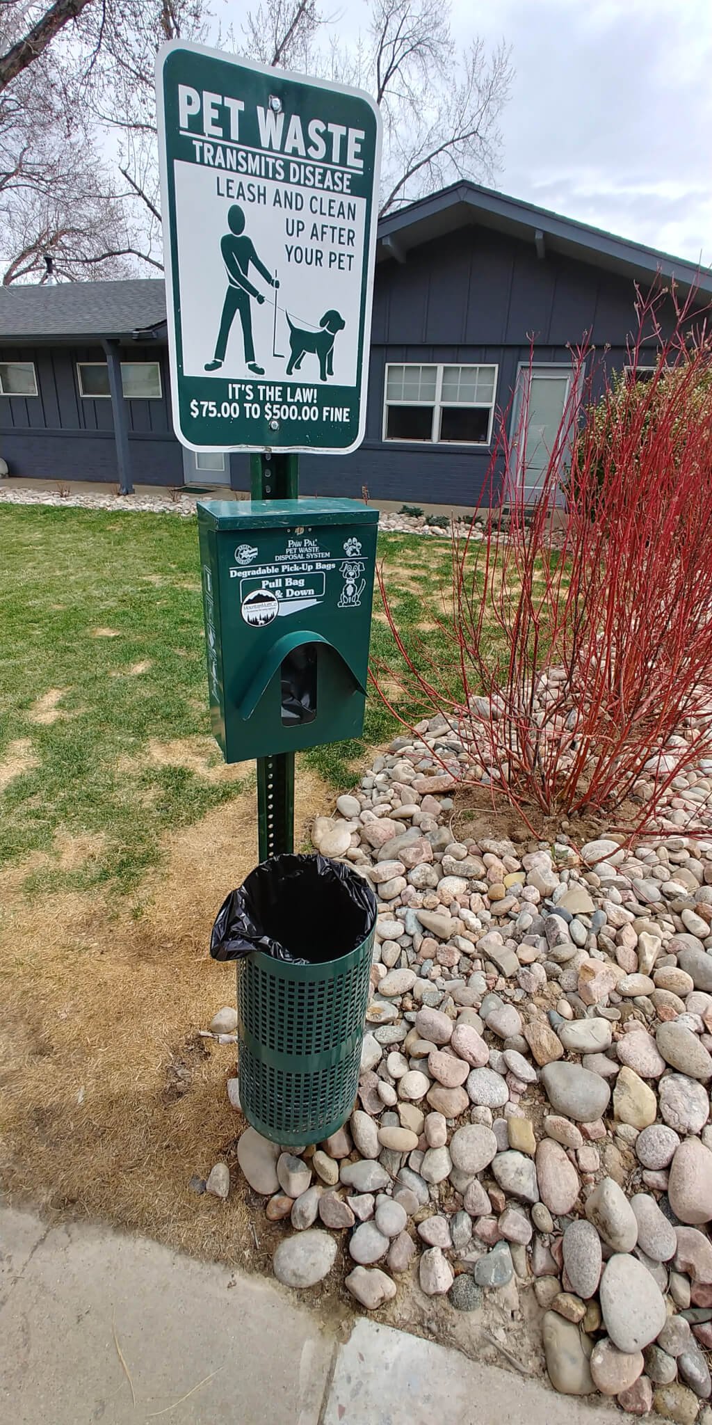 Pet waste station with bags and trash can - at the dog walk area at our Boulder CO rentals.